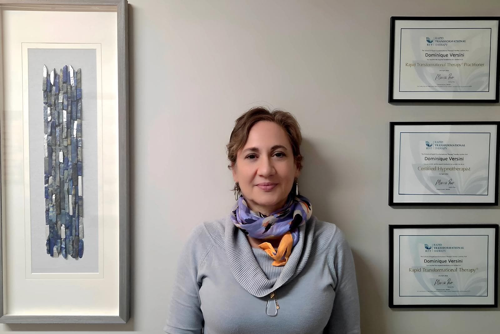 Dominique with certificates and artwork